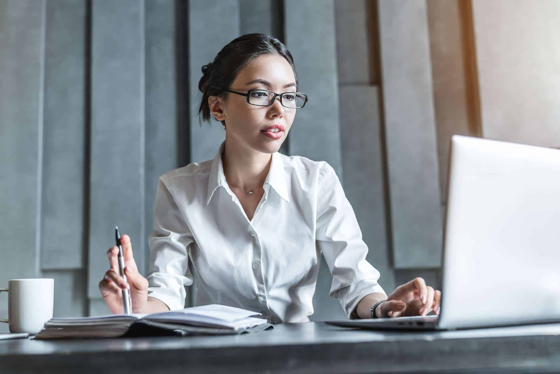 Portrait of serious businesswoman using laptop in office
